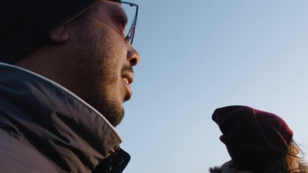 接近非裔美国男人站在山顶上与白人女人站在一起 年轻夫妇喜欢看风景 看日落 聊天和喝茶 多民族徒步旅行者在山中度假 — 图库视频影像