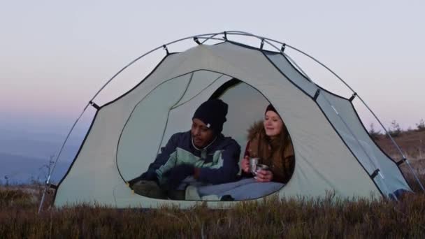 Genç Iki Yürüyüşçü Tepedeki Çadırda Oturur Konuşur Çay Içerler Beyaz — Stok video