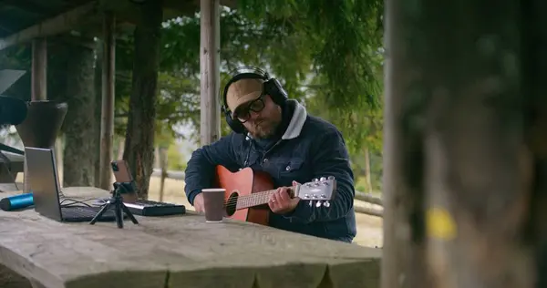 Caucasian Man Headphones Plays Guitar Sitting Wooden Gazebo Forest Professional — Stock Photo, Image