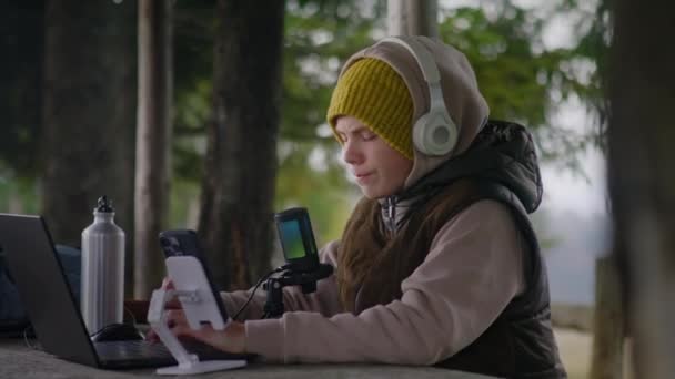 Young Streamer Usa Laptop Telefone Tripé Para Streaming Jogos Durante — Vídeo de Stock
