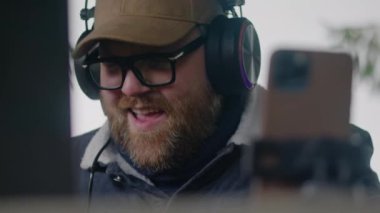 Kafkasyalı bir müzisyenin kulaklıklarıyla MIDI klavyesini kapatarak müzik yaratıyor ve ormanda çardakta ritmik bir şekilde oturuyor. Yetişkin adam dışarıda şarkı kaydetmek için bilgisayarını ve telefonunu tripoda kullanıyor..