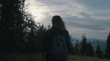 Sırt çantaları ve yürüyüş direkleriyle tepenin üzerinde manzaralı yürüyüş yapan çeşitli yürüyüşçülerin çekimini takip ediyoruz. Yürüyüş sırasında ya da dağ gezisinde bir grup arkadaş. Açık hava meraklıları.