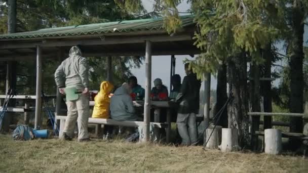 多姿多彩的徒步旅行伙伴聊着天 把徒步旅行的食物装进袋子里准备晚餐 一群游客在森林里走完长途跋涉后在加泽博休息 度假远足或远足登山人士 — 图库视频影像