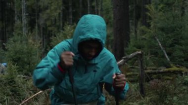 Sırt çantaları ve yürüyüş direkleri olan çeşitli gezginler güzel ormanda yürürler. Yürüyüş sırasında ya da dağlarda gezintiye çıkarken kankayız. Doğa keşfi ve turizm kavramı. Yavaş çekim.