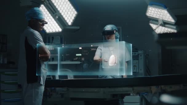 Ar耳机中的多种族外科医生在高科技手术室工作 医疗专业人员使用人工智能虚拟全息图显示 健康监测器和人体器官的三维图形 医疗保健的未来 — 图库视频影像