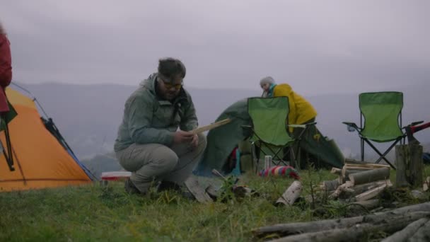 Adult Caucasian Man Lights Campfire Talks His Hiking Buddies Woman — Stock Video