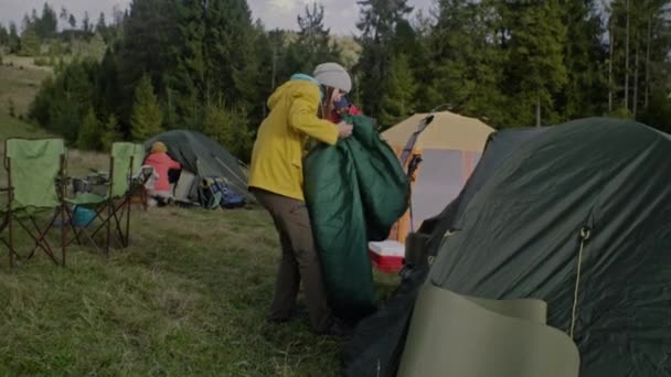 Туристы Вместе Расставляют Палатки Раскладывают Спальные Мешки Группа Этнических Путешественников — стоковое видео