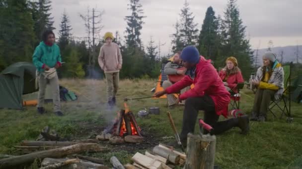 African American Hiker Cooks Marshmallow Campfire Gives Teenager Caucasian Man — Stock Video