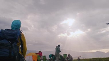 Sırt çantalı bir grup açık hava meraklısı kamp yapmak için mola verdi. Gezginler ormanda uzun bir yolculuktan sonra çadırlar kurdular ve ateş yaktılar. Doğa keşfi ve turizm kavramı. Yavaş çekim.
