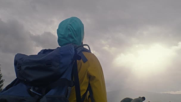 背负背包的游客站在山上欣赏美丽的日落 旅行团经过远征后在露营时停下来休息 自然发现和旅游的概念 慢动作 — 图库视频影像