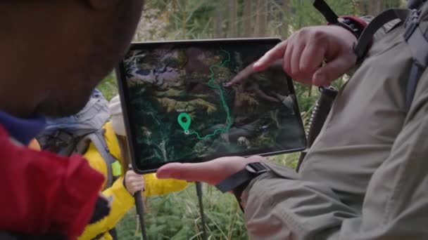 디지털 태블릿 컴퓨터를 하이커의 닫습니다 산림에 표시된지도와 트레일 방법이있는 태블릿 — 비디오