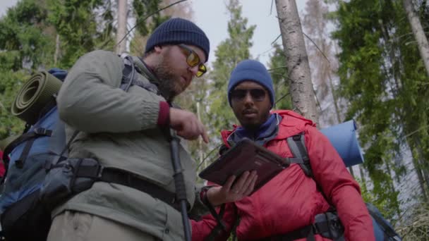 관광객 숲에서 태블릿 컴퓨터를 트레일 방법을 배낭과 트레킹 여행자는 하이킹 — 비디오