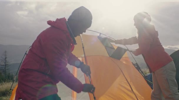 複数のハイカー集団が集まってキャンプ場を作った 旅行者はテントをセットアップし テントの上にソーラーパネルを置きます 観光客は長い遠征の後 休憩をとった 自然の発見 スローモーション — ストック動画