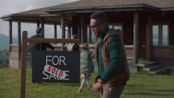 Afro Amerikalı Emlakçı Satılık Tabelası Için Etiket Yapıştırıyor Kameraya Bakıyor — Stok video