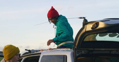 Bir grup turist arabadan iniyor, bagajlarını boşaltıyor ve dağ yürüyüşü için bagajlarını hazırlıyorlar. Tatil sırasında aile ya da yürüyüş arkadaşları. Açık hava meraklıları. Yavaş çekim.