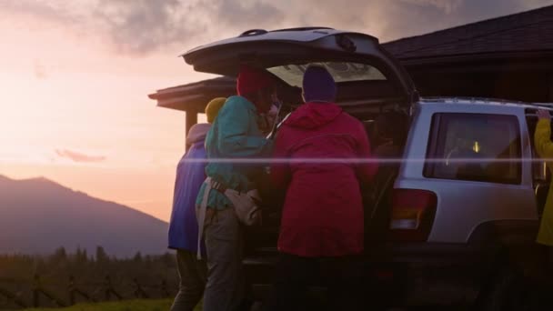 다양한 여행자의 하이킹 자동차의 트렁크에 배낭을 관광객 가족은 오두막을 떠납니다 — 비디오