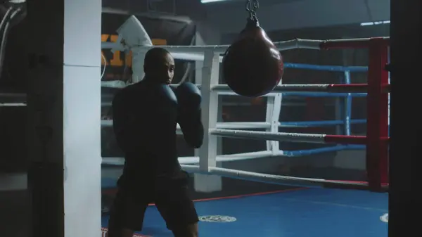 Confident African American Fighter Hits Punching Bag While Training Dark — Stock Photo, Image