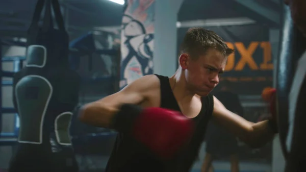 Sebevědomý Mladý Bojovník Udeří Boxovací Pytel Při Tréninku Tmavé Boxerské — Stock fotografie