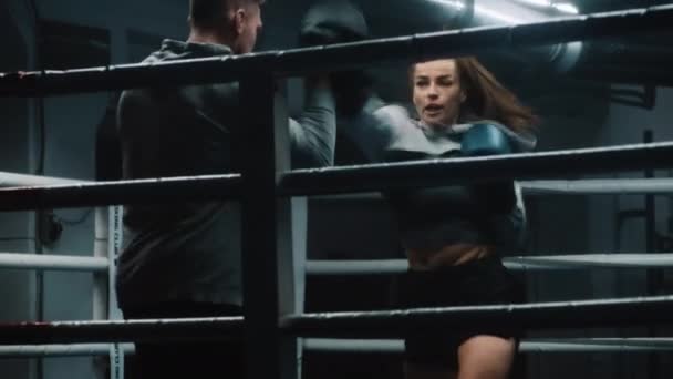 장갑의 전투기는 어두운 체육관에서 경쟁하기 트레이너와 기술을 싸우는 운동선수 여성은 — 비디오