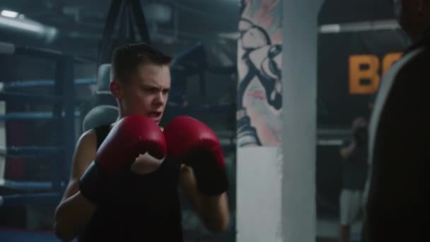 Jovem Lutador Confiante Bate Sacos Perfuração Enquanto Treina Ginásio Boxe — Vídeo de Stock