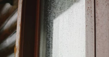 Kırsal ya da dağlardaki evlerin dışındaki sisli cam yüzeyine düşen yağmur damlalarını yakından çek. Sonbaharda açık havada rüzgarlı, yağmurlu ve nemli hava. Doğanın güzelliği.