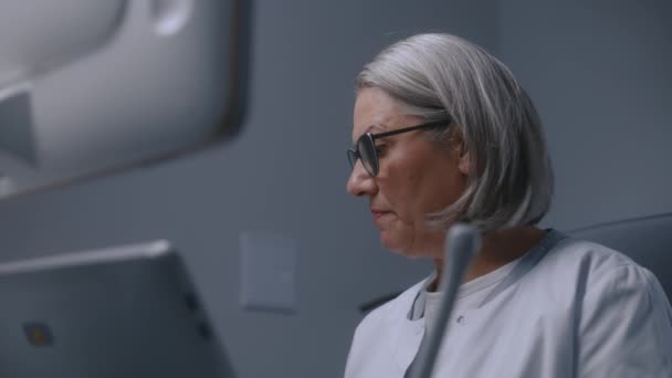 Olgun Kadın Doktor Ultrason Cihazının Ultrasona Bakıp Ultrason Taraması Yapıyor — Stok video