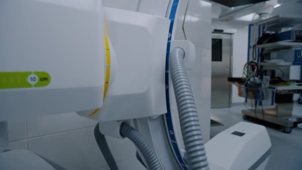 最新の病院のオペレーティングルームに立っているデジタルで革新的なX線システムのドリーショット 手術の準備ができている高度な機器 クリニックや医療施設の明るいオペレーティングブロック — ストック動画
