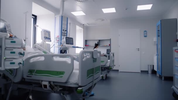 医院有现代化设备的急救室 戴氧气面罩的老年人在手术成功后躺在床上睡觉 护士在医疗设施重症监护病房的电脑上工作 — 图库视频影像