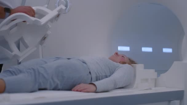 女性の患者は 脳と体をスキャンするためにマシンの内部に移動するMriまたはCtスキャンベッドに横たわります 放射線科医がコントロールし 白人女性の癌予防検査のためのスキャナーをオンにする — ストック動画