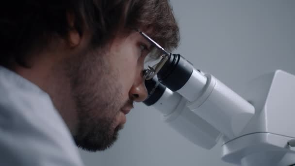 실험실에서 박테리아 샘플을 연구하고 분석하는 현미경을 바라보는 과학자의 초상화 화학은 — 비디오