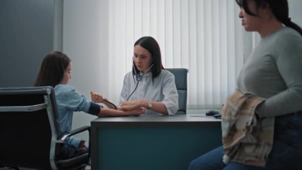 Kvinna Familjeläkare Läkaren Mäter Blodtrycket Hos Unga Patienter Med Hjälp — Stockvideo