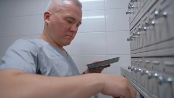 Erkek Bilim Adamı Tıbbi Metal Deposundaki Raflı Araştırmalar Için Kan — Stok video