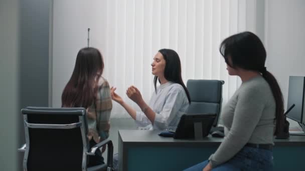 女性医師 内分泌学者は 病院のオフィスの若い女の子の甲状腺をチェックします アジアの家族は診察を受けるか クリニックで医師の診察を受ける ヘルスケアの概念 — ストック動画