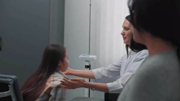 女性内分泌学家检查住院亚洲女孩的甲状腺 年轻病人在诊所接受检查或做检查 母亲与医学专业人员交谈 保健的概念 — 图库视频影像