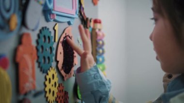 Asyalı genç kız modern hastanenin bekleme salonunda oyuncaklarla oynuyor. Çocuk klinikte muayene ya da prosedür için bekliyor. Çocuk ilaçları ve sağlık hizmetleri. Kapat..