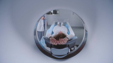Tomografide, PET 'te ya da MRI taramasında yatarken ve makinenin içinde hareket ederken yakın plan çek. Yüksek teknolojili modern ekipmanlar kullanarak hasta vücudunu ve beynini tarıyorum. Gelişmiş teknolojili tıbbi tesis..