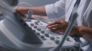 Doktora ultrason cihazıyla yaklaşın. Profesyonel doktor karın organları sonografisi yapar ve kadın hastaları muayene eder. Gelişmiş tıbbi donanımlı modern klinik ya da hastane.