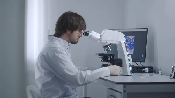 Mužský Vědec Podívá Pod Mikroskop Analyzuje Bakterie Nebo Krevní Vzorky — Stock fotografie