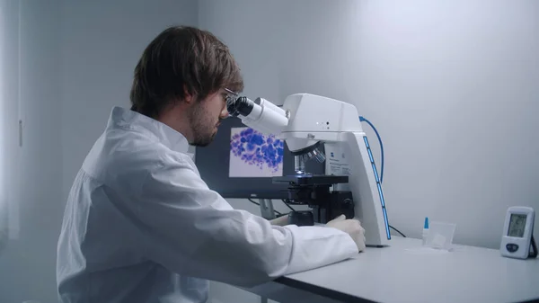 Mannelijke Wetenschapper Kijkt Onder Microscoop Analyseert Bacteriën Bloedmonsters Moderne Biotechnologie — Stockfoto
