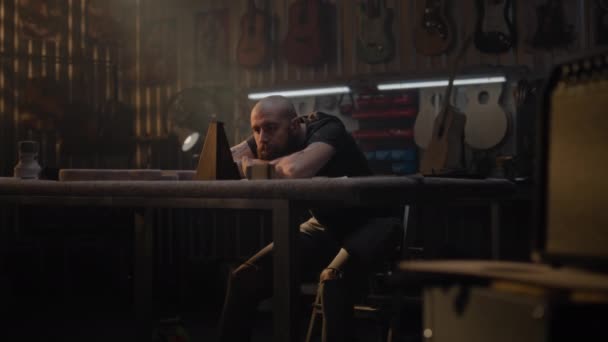소진된 장인은 메트로놈을보고 악기를 만들기위한 작업장에 앉아있다 목수는 기타가 있습니다 — 비디오