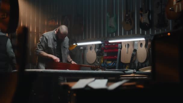 Профессиональный Плотник Вытирает Акустическую Гитару Струны Тряпкой Деревообрабатывающий Мастер Изготавливает — стоковое видео
