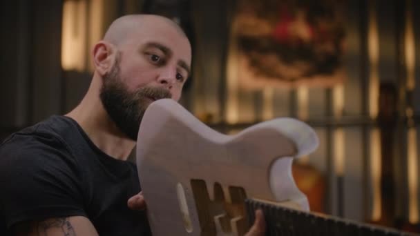 Крупный План Мужчины Плотника Прикрепляющего Гитарную Шею Корпусу Гитары После — стоковое видео