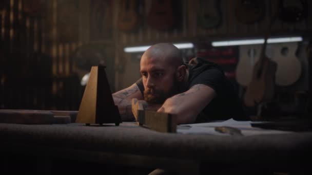Tired Artisan Craftsman Looks Metronome Sits Stylish Workshop Making Musical — Stock Video