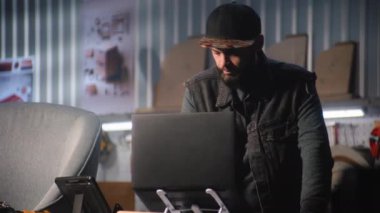 Erkek marangoz veya tasarımcı tablet bilgisayar ve dizüstü bilgisayar kullanarak hesaplamalar yapar. Zanaatkar, modern mobilya atölyesinde sandalye yapmak veya restore etmek için çalışıyor. El yapımı ve girişimcilik kavramı.