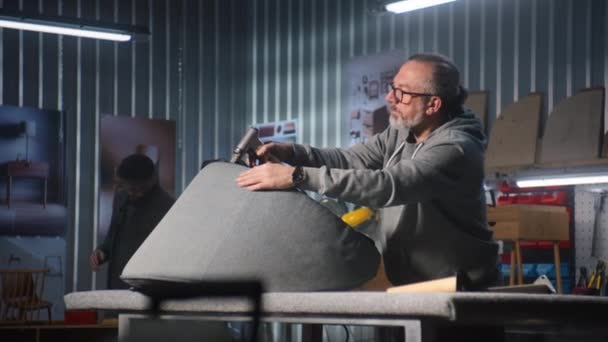 Ώριμος Ξυλουργός Ανασχηματίζει Καρέκλα Χρησιμοποιώντας Συρραπτικό Όπλο Άντρας Συνάδελφος Συναρμολογεί — Αρχείο Βίντεο