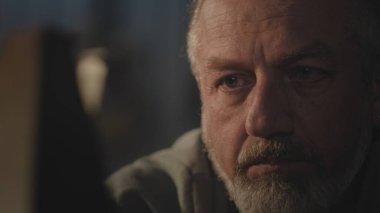 Kafkas zanaatkarının işten sonra dinlenme yerini kapatın ve karanlık atölyede metronoma bakın. Olgun bir zanaatkar gözlüğünü çıkarır ve ellerinin üzerine uzanır. El işi ve küçük işletme konsepti.