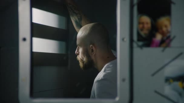 从监狱里的窗户往外看的一面镜子中的男性囚犯的倒影 家人的照片挂在镜子旁边 犯人在狱中服刑 拘留中心或教养所 — 图库视频影像