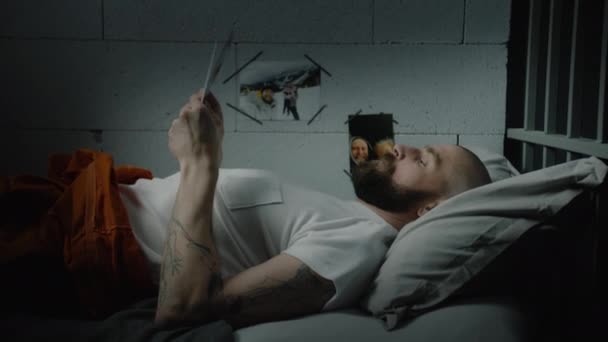 Male Prisoner Orange Uniform Lies Bed Prison Cell Looks Pictures — Stock Video