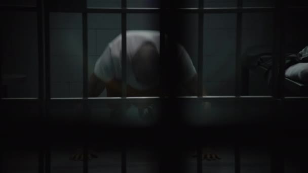 Więzień Pomarańczowym Mundurze Rozgrzewa Się Ćwiczy Robi Pompki Więziennej Celi — Wideo stockowe