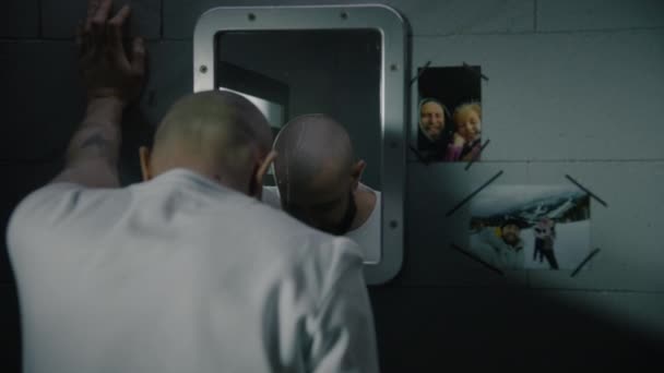 Deprimovaný Vězeň Stojí Vězeňské Cele Dívá Obrázky Rodinou Zavěšenou Zrcadla — Stock video